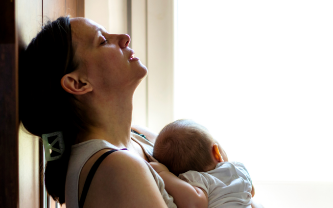 mother and baby leaning against window