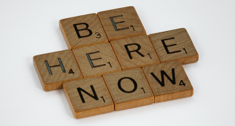 scrabble tiles that read 'be here now'