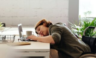 woman asleep at her desk with her laptop open