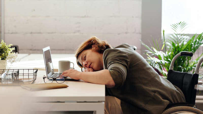woman asleep at her desk with her laptop open