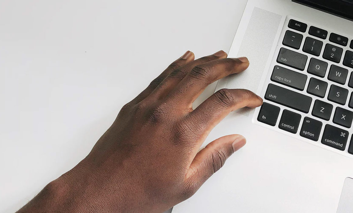 a person's hand on a laptop keyboard