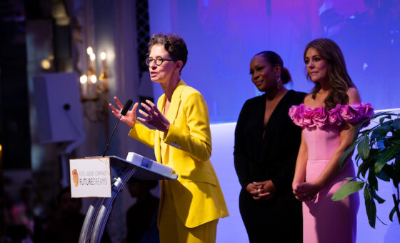 Dr Liz O'Riordan makes her acceptance speech on stage with Elizabeth Hurley and Leanne Pero