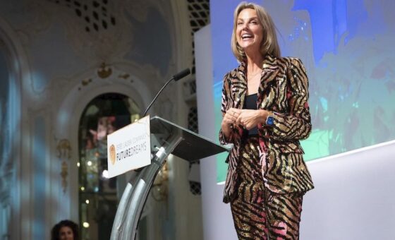 Helen Addis smiles as she receives the Future Dreams Lightning Bolt Award. She's wearing a very sparkly, black and gold zebra print suit.