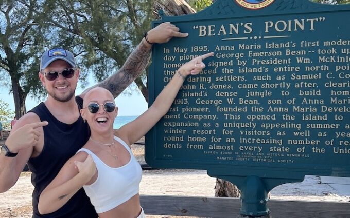 Alex and Nicky Newman at a sign reading Bean