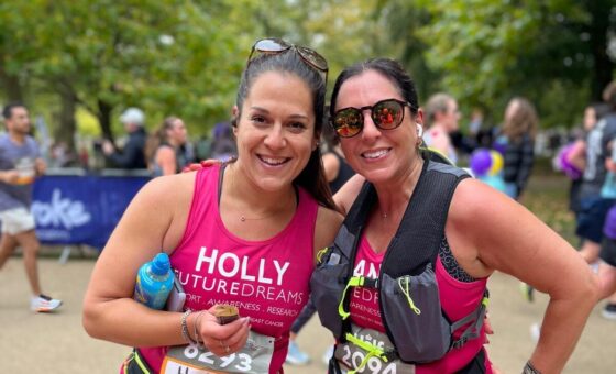 Two runners in pink running vests on route