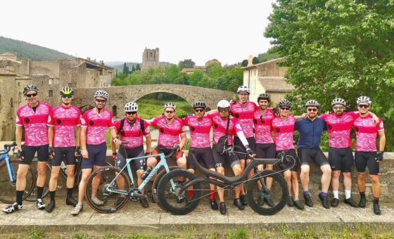 Group of cyclists in bright pink branded t-shirts