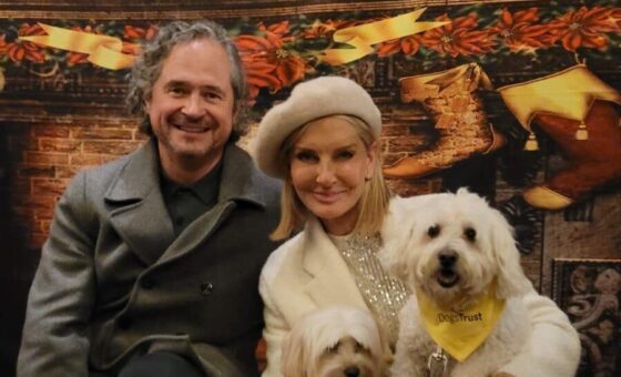 Jacquie and her husband looking festive with a dog