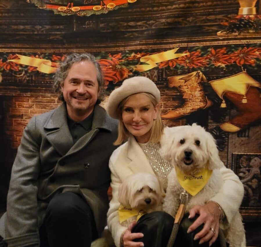 Jacquie and her husband looking festive with a dog